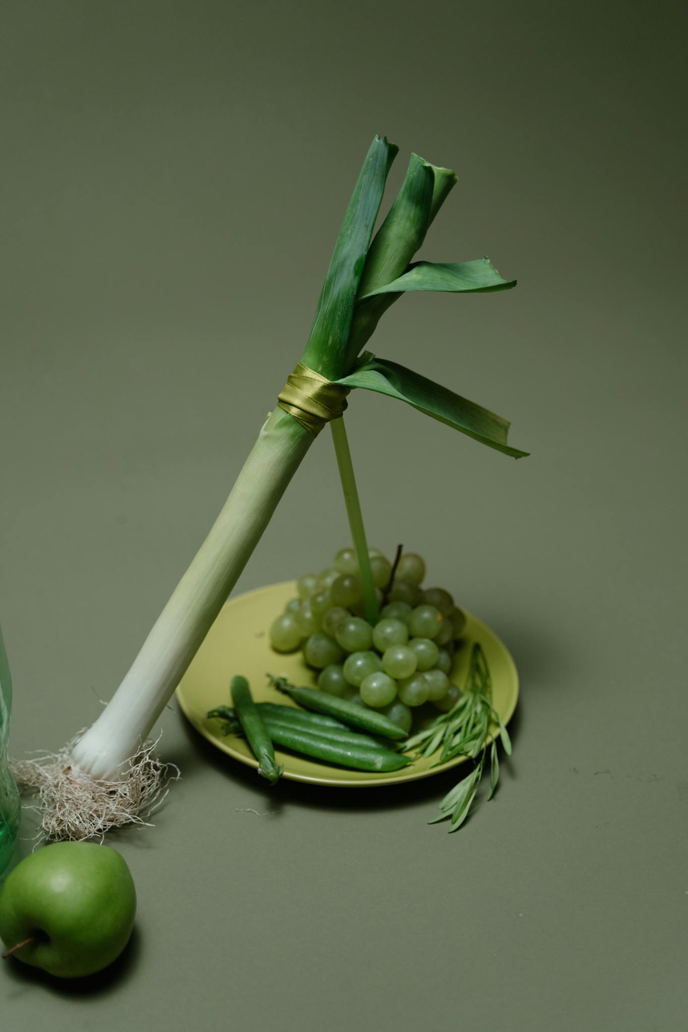 Aesthetic still life of green vegetables and fruits on a minimalist background.